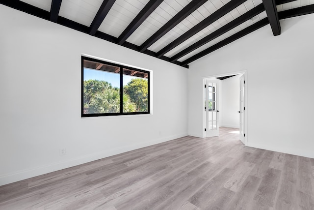 spare room with vaulted ceiling with beams and light hardwood / wood-style flooring