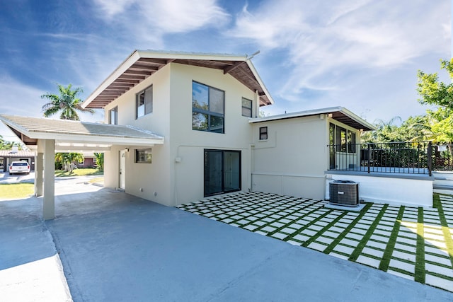 view of side of property with central AC unit and a patio