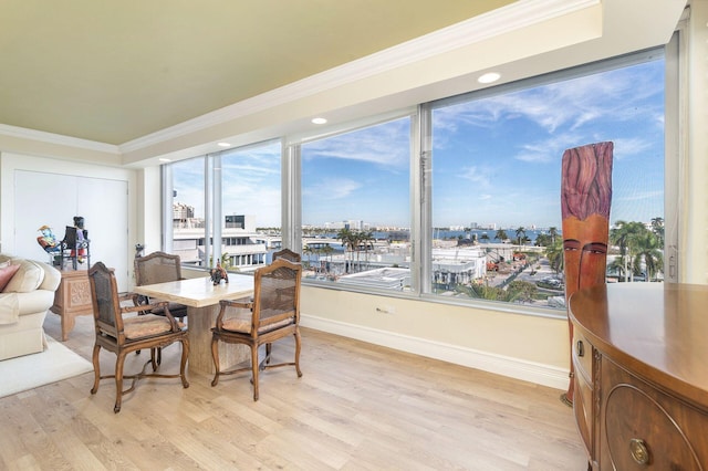 dining space featuring crown molding, a healthy amount of sunlight, and light hardwood / wood-style floors