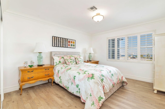 bedroom featuring ornamental molding and light hardwood / wood-style flooring