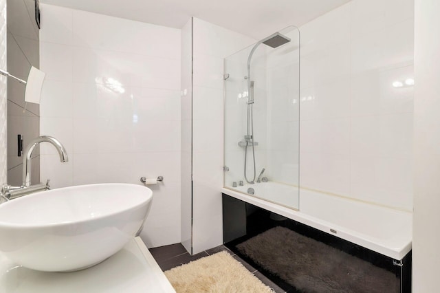 bathroom featuring tile walls, sink, and tiled shower / bath