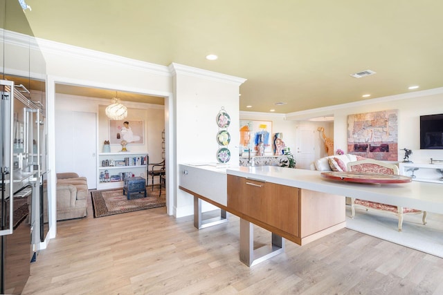 kitchen with ornamental molding and light hardwood / wood-style floors