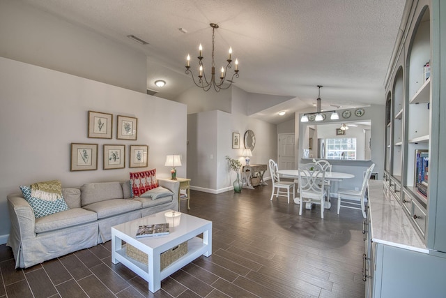 living room with vaulted ceiling, dark wood-type flooring, a chandelier, and a textured ceiling