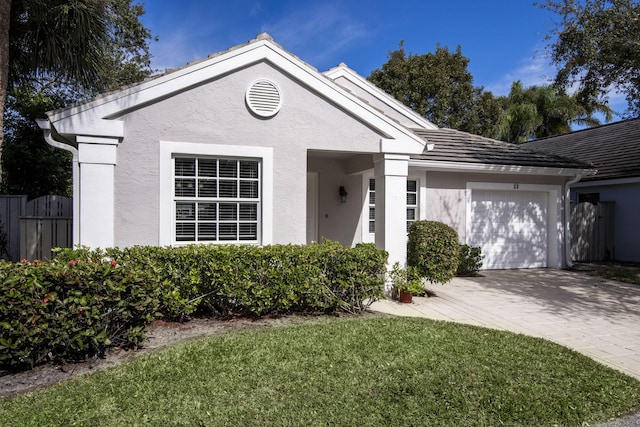 ranch-style house with a garage and a front lawn