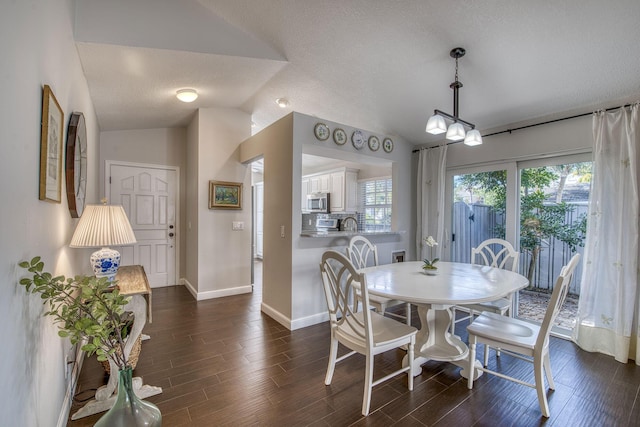 dining room featuring vaulted ceiling, baseboards, dark wood-style floors, and a textured ceiling