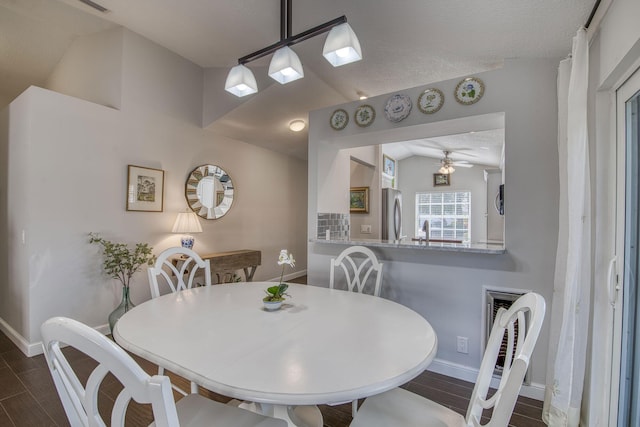 dining area with vaulted ceiling, baseboards, dark wood-style floors, a ceiling fan, and a textured ceiling