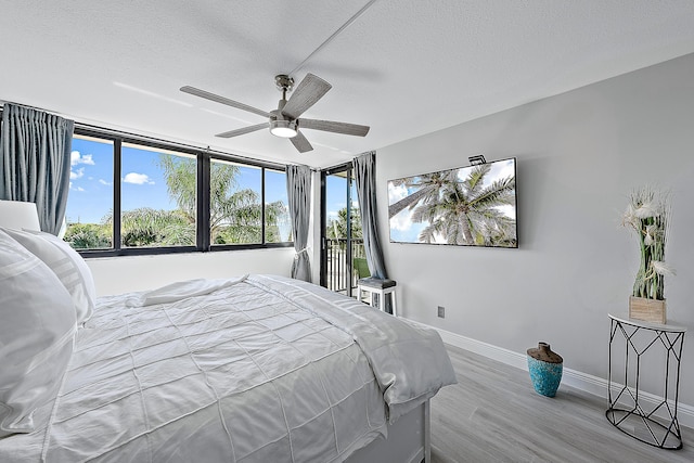 bedroom with ceiling fan, hardwood / wood-style flooring, and a textured ceiling