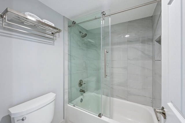 bathroom with combined bath / shower with glass door and toilet