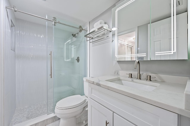 bathroom with walk in shower, vanity, and toilet