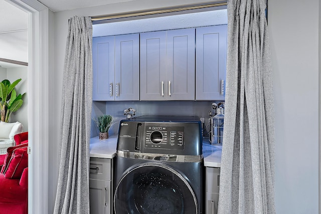 washroom with washer / clothes dryer and cabinets