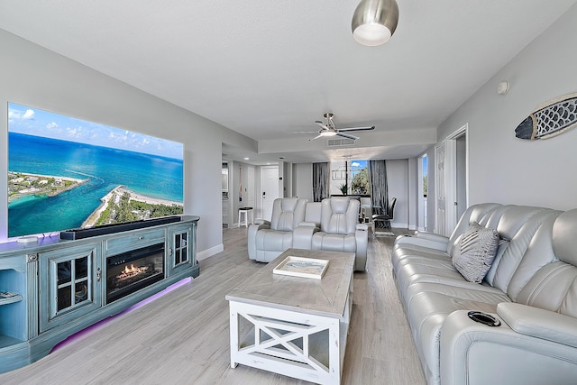 living room with ceiling fan and light wood-type flooring