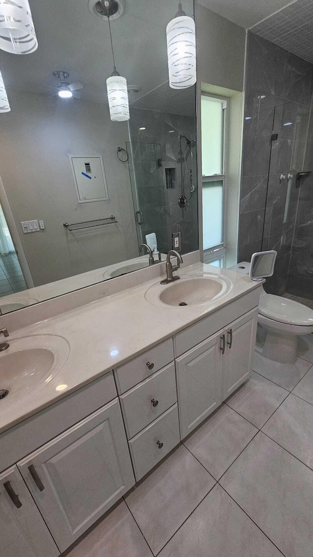 bathroom with tile patterned flooring, vanity, toilet, and walk in shower