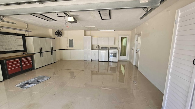 garage featuring a garage door opener, electric panel, and washer and clothes dryer