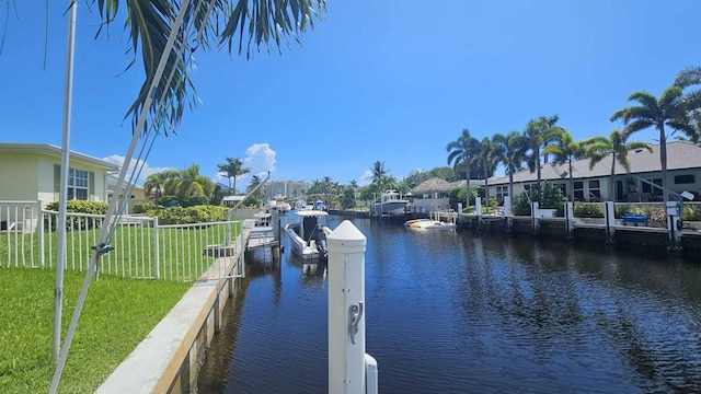 dock area with a water view and a lawn