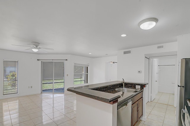 kitchen featuring appliances with stainless steel finishes, sink, a kitchen island with sink, light tile patterned floors, and ceiling fan