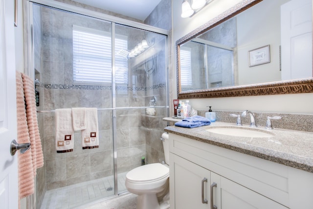 bathroom featuring vanity, an enclosed shower, a wealth of natural light, and toilet