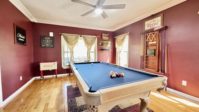 recreation room featuring ceiling fan, a textured ceiling, baseboards, and wood finished floors