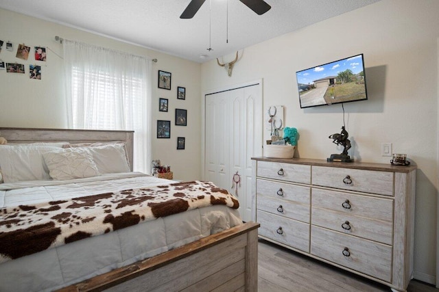 bedroom with light hardwood / wood-style flooring, a closet, and ceiling fan