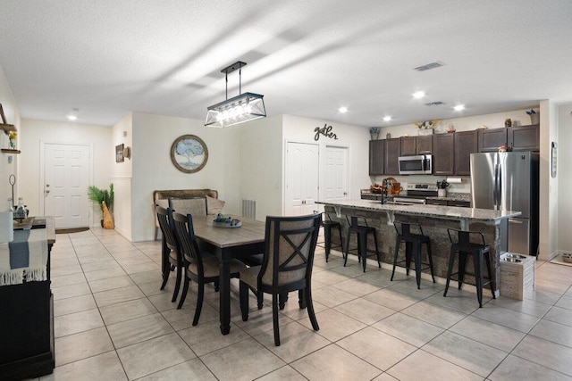 tiled dining space with a textured ceiling