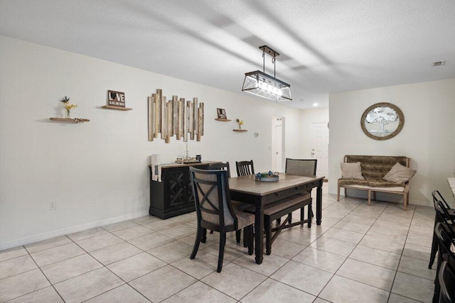 dining space with light tile patterned floors and a textured ceiling