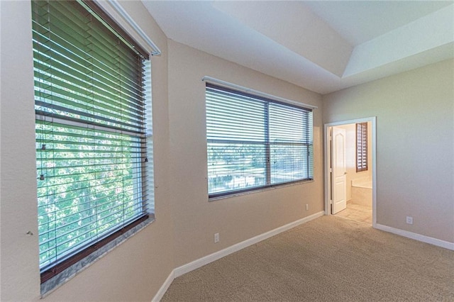 unfurnished bedroom featuring ensuite bathroom and light carpet