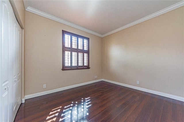 spare room with dark hardwood / wood-style flooring and crown molding