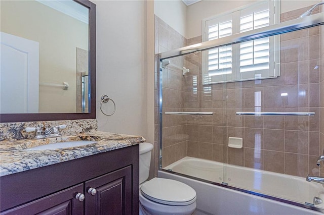 full bathroom featuring vanity, shower / bath combination with glass door, and toilet