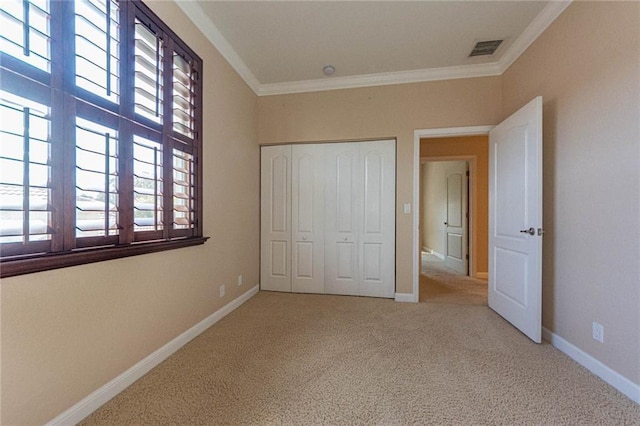 unfurnished bedroom featuring ornamental molding, light carpet, and a closet