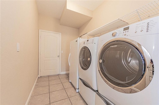 laundry room with light tile patterned flooring and washing machine and clothes dryer