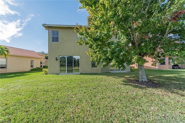 rear view of property with a lawn