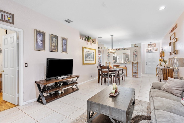 living room with a notable chandelier and light tile patterned flooring