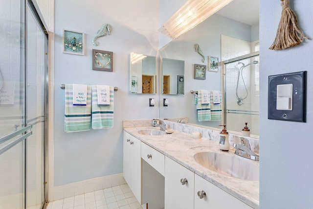 bathroom featuring tile patterned flooring, vanity, and walk in shower