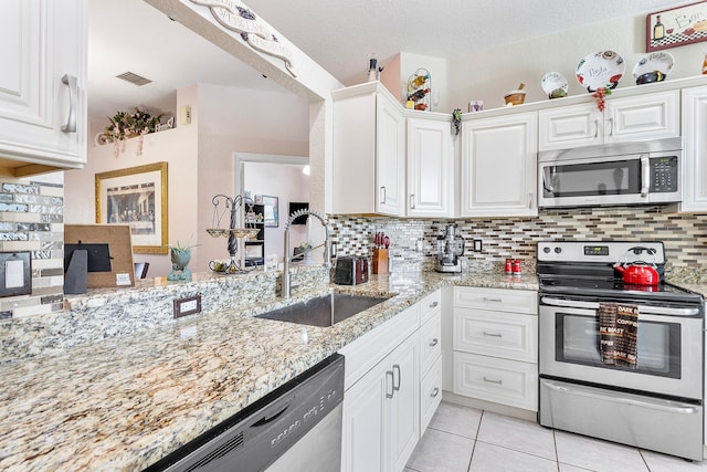 kitchen featuring light stone counters, appliances with stainless steel finishes, sink, and white cabinets