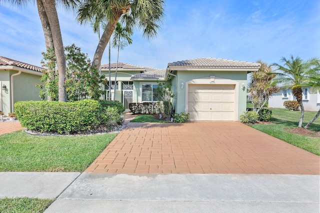 mediterranean / spanish-style home with a garage and a front lawn