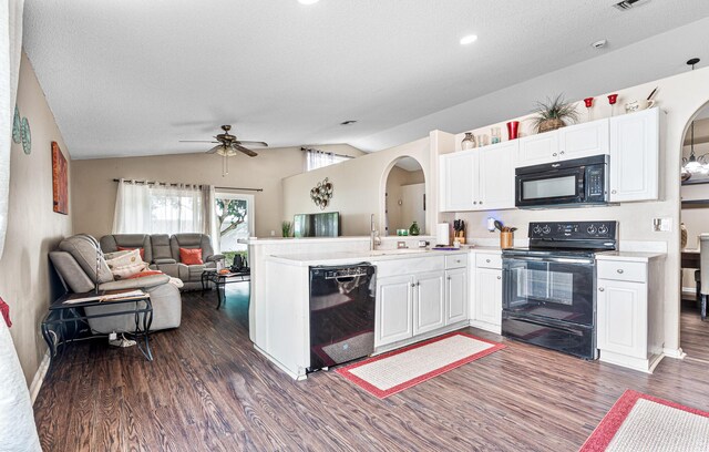 kitchen featuring white cabinetry, black appliances, dark hardwood / wood-style flooring, vaulted ceiling, and kitchen peninsula