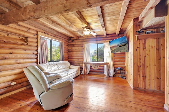 unfurnished living room with beamed ceiling, a healthy amount of sunlight, wood ceiling, and light wood-type flooring