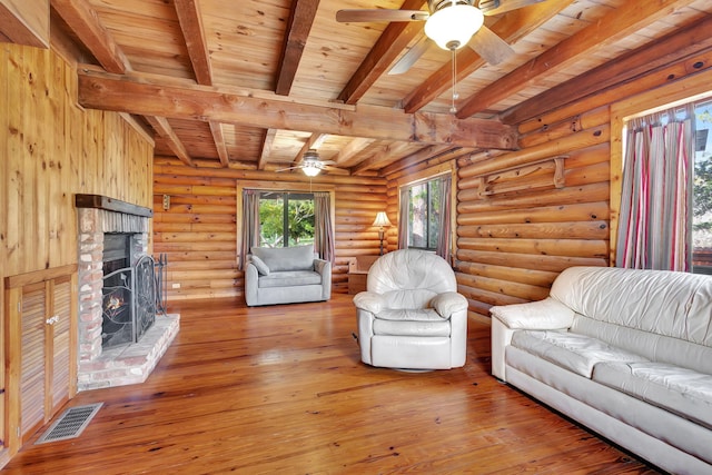 unfurnished living room featuring hardwood / wood-style floors, a fireplace, ceiling fan, wooden ceiling, and beam ceiling