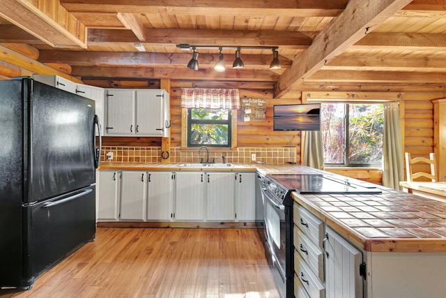 kitchen featuring wood ceiling, light hardwood / wood-style flooring, tile counters, black appliances, and white cabinets