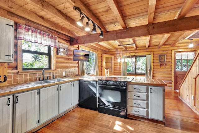 kitchen featuring decorative light fixtures, tile counters, kitchen peninsula, white cabinets, and black appliances