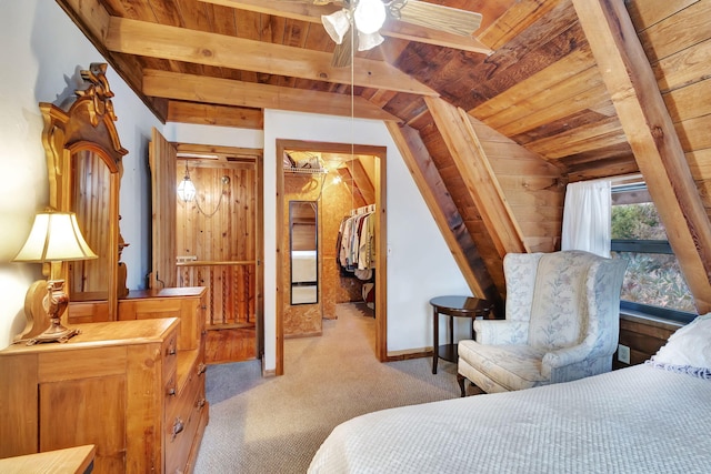 bedroom featuring vaulted ceiling with beams, light colored carpet, a walk in closet, and wooden ceiling