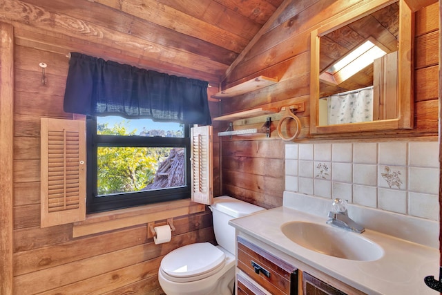 bathroom featuring toilet, vanity, curtained shower, vaulted ceiling with skylight, and decorative backsplash