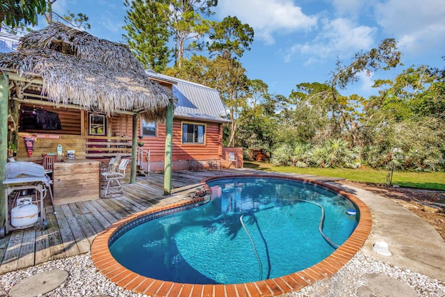 view of swimming pool featuring area for grilling and a deck