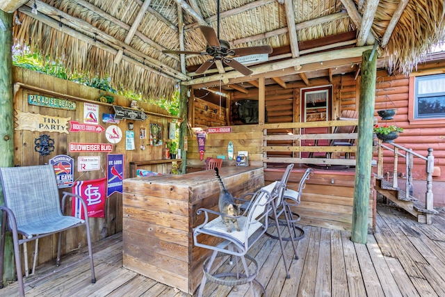 wooden terrace with an outdoor bar and ceiling fan