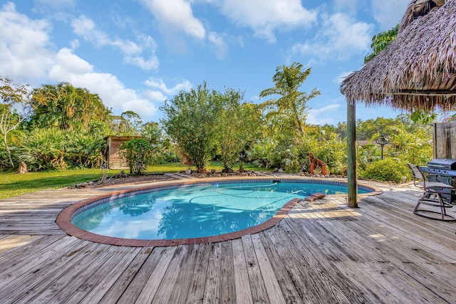 view of swimming pool featuring a storage shed and a deck