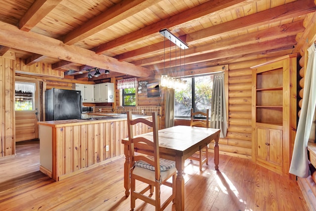 dining area with beam ceiling, rustic walls, wood ceiling, and light hardwood / wood-style floors