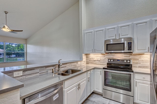 kitchen featuring stainless steel appliances, white cabinetry, sink, and backsplash