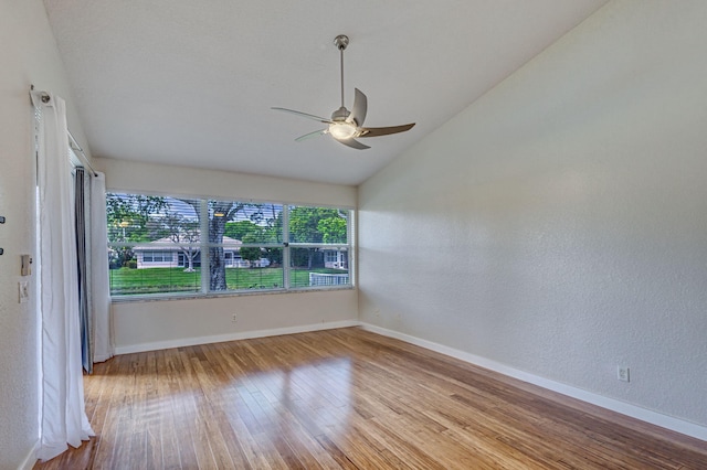 spare room with vaulted ceiling, ceiling fan, and light hardwood / wood-style flooring