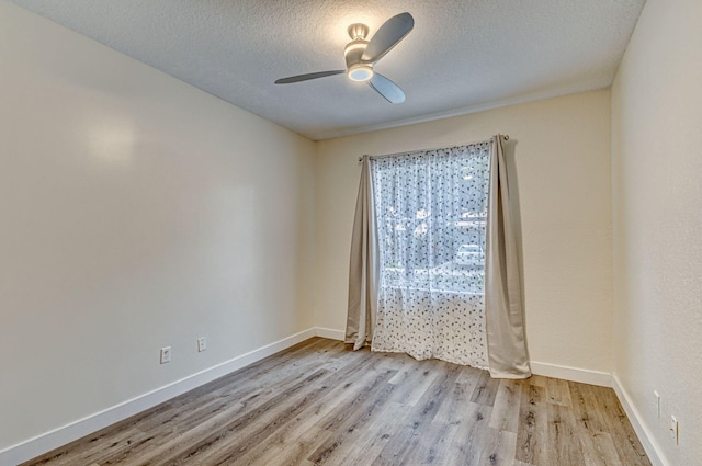 empty room featuring a textured ceiling, light hardwood / wood-style floors, and ceiling fan