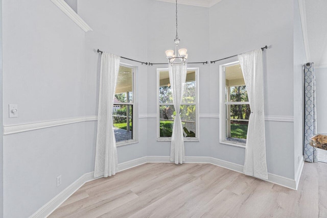 unfurnished dining area with a notable chandelier, plenty of natural light, and light wood-type flooring