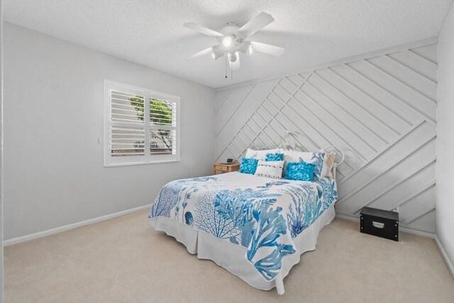 unfurnished room featuring light carpet, a textured ceiling, plenty of natural light, and ceiling fan